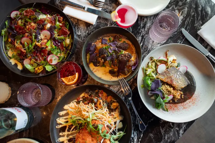 A table topped with lots of plates of food